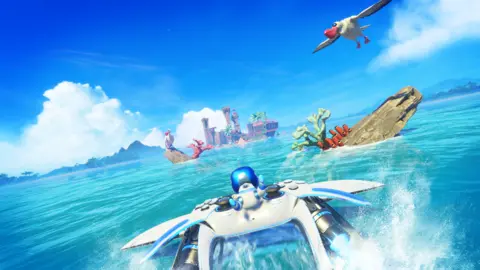 Team Asobi 一张截图显示，Astro Bot 紧紧抓住一个飞行的 PS5 控制器，它俯冲到海面附近，向空中喷出水花。岩石障碍物挡住了他前往目的地的路——一个遥远的岛屿，岸边有一艘失事的船。